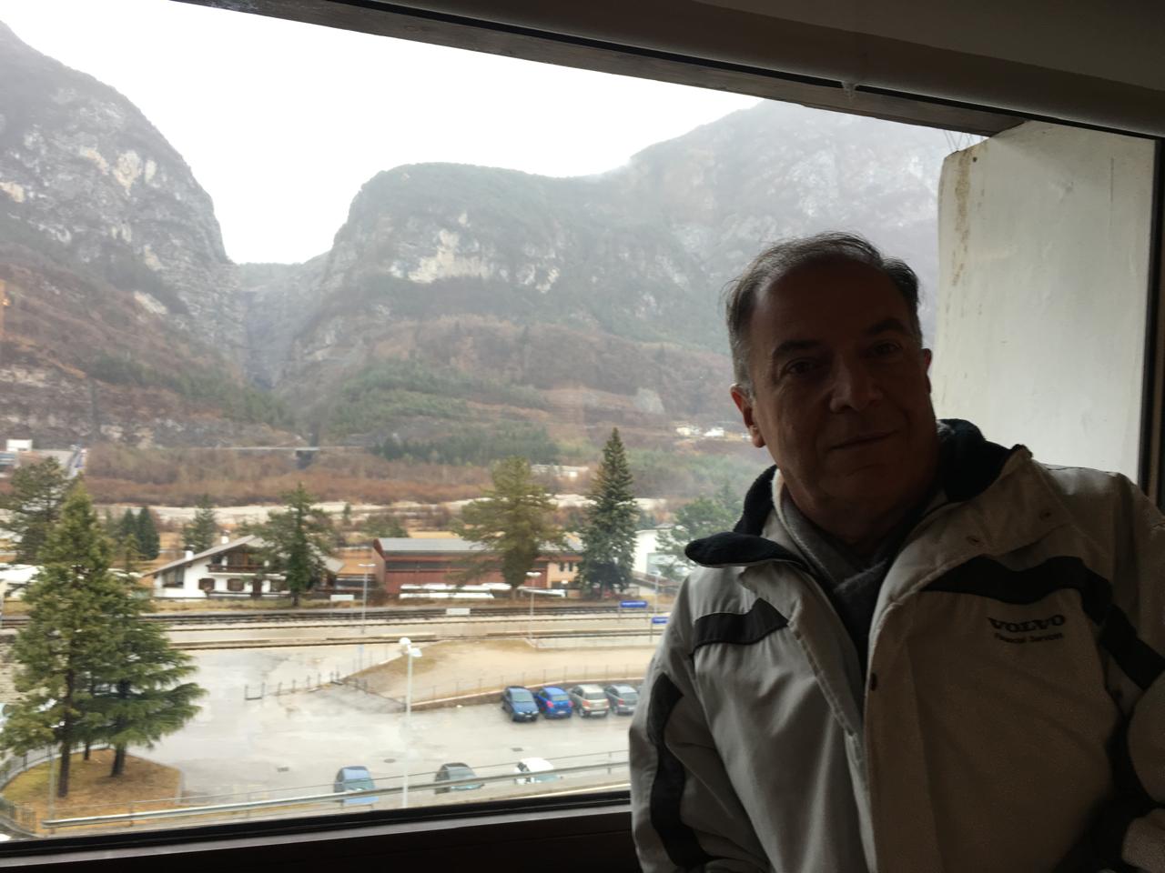 Cides Fontanella à janela, com Longarone e os Dolomitas ao fundo.